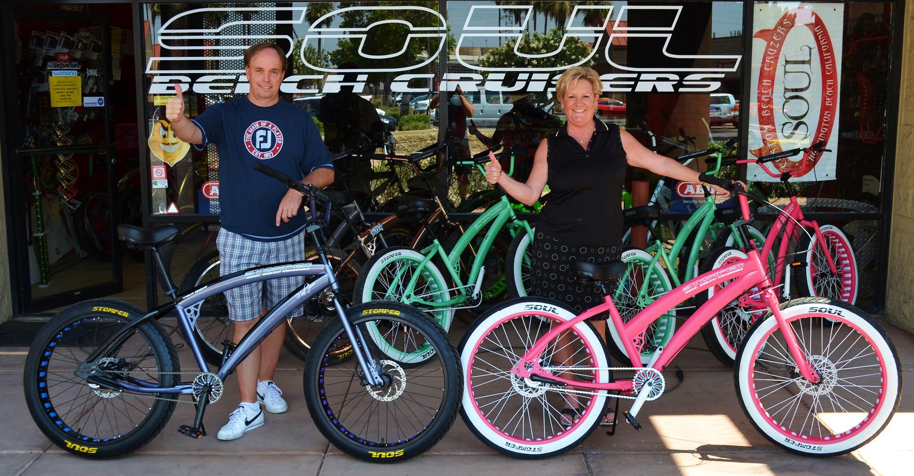 Two people with their bikes in front of a store