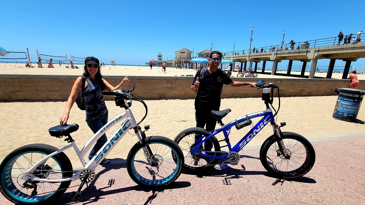 Two people with their bikes at the beach