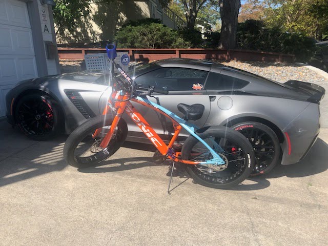 A bike next to a sports car